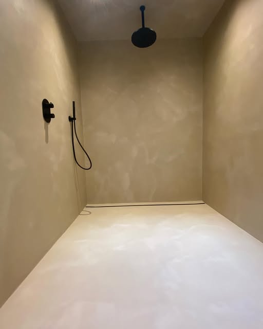 Inloopdouche met naadloze decoratieve wandafwerking en zwarte kraanwerken